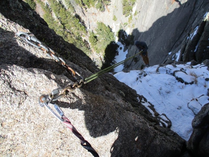 The first rappel goes down the gully to the west. Look for the bolted station just down and west from the summit.