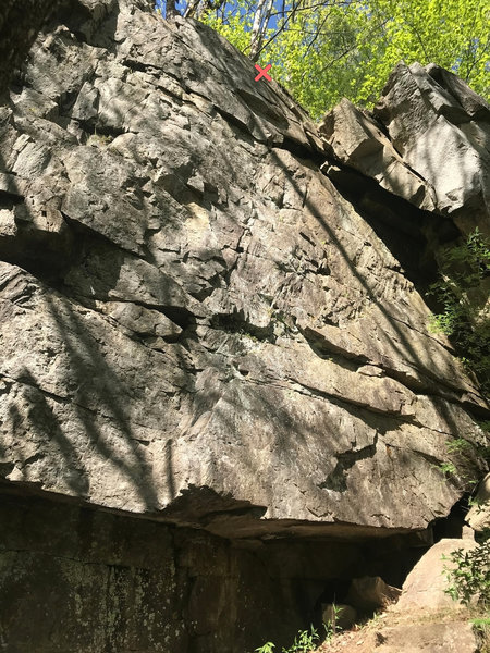 Photo of the wall. A pair of bolts at the top of the wall marked by the X. Easy to the top of the wall. A tree with a chain is there to help access.