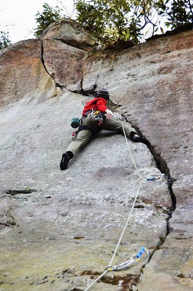Approaching the first crux on Wandering Crack. Smear left foot on tiny nub on face, jam hands or lie back to step up to a good stance.