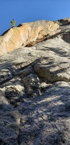 You can see the rope going over the first "mini-roof" below the tree in the photo. Pulling the roof is the first crux. If you take the dihedral to its end and belay on the ledge at the top, the pitch is 11+.