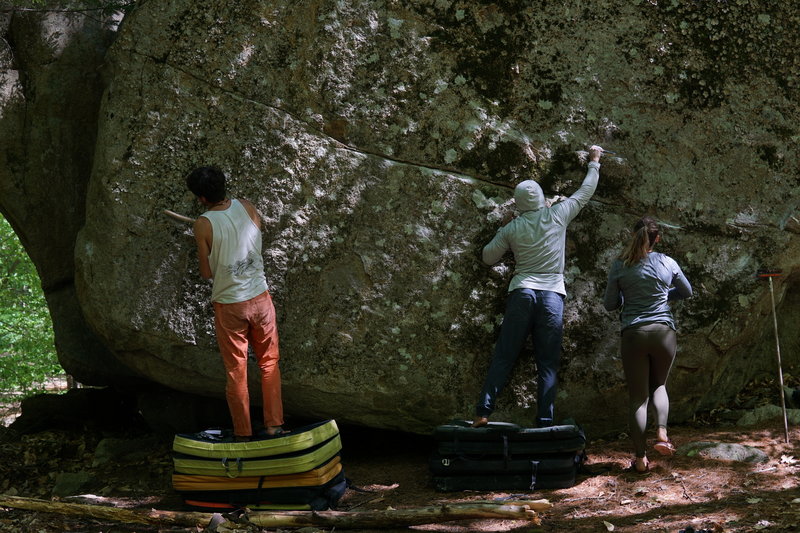 People for scale on how Tall this boulder is. Topout needs a good scrub.