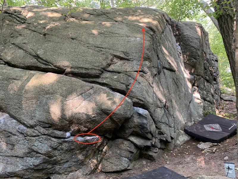 Start on the circled rail, and then follow the arrow. It's a short traverse right and then up the arête slab.