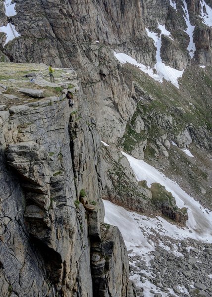 Standing at the top of the wall with backpacks hung on the 70m rappel route.