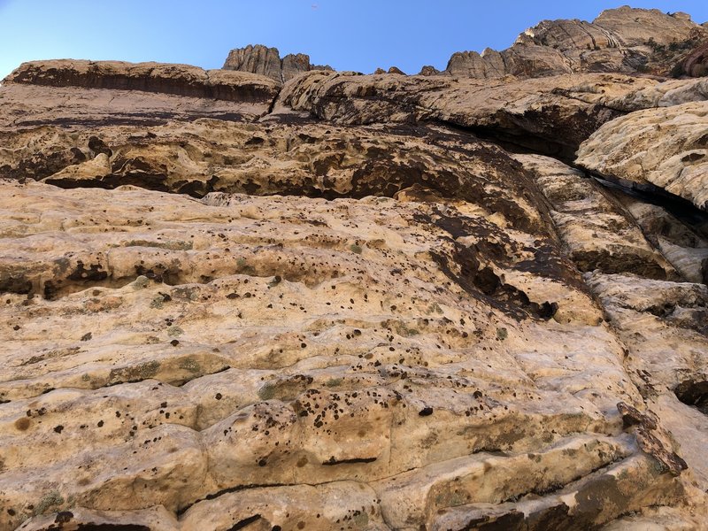 The "wave" feature is in the upper left corner of this image. From the location of this image, a 60m rope can reach the next belay which is in a large dark patina'd depression hidden above the wave and at the base of a nice vertical crack.