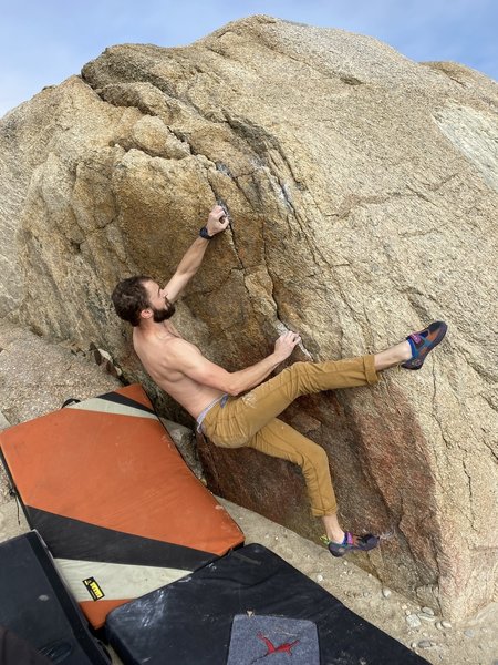 The climber's right hand is still on the starting hold. You can get an unnecessary but comfy right heel hook.