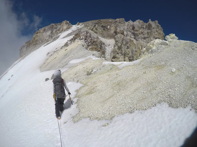 Traverse of the crater rim. The conditions on the rim vary between ok snow to gravel to rock. The rock outcropping to the left is the top of el Pulpito. The summit is the high point in the center of the photo.