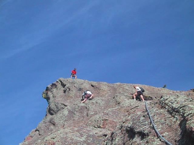 Bill does a cool hip belay on the summit of the Fifth. Scott and Bernard are nearing the summit.