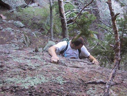 Scott executes the crux move on the secret downclimb.