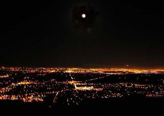 Moon rising over Boulder from the east face of the Third Flatiron.
