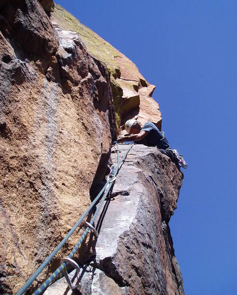 Finishing the scary move right around the arete to get to the hand crack on pitch 5.
