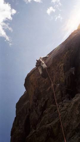 On the crux roof of P2. Note the single cam with long runner well below his feet.