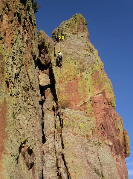 Chockstone Chimney rappel route. From the top of Upper Ruper, scramble uphill to a wide notch, then down the other side to two huge bolt hangers on the left wall of the chimney. A 100' rappel with a 60m rope takes you to the Upper Ramp; watch the ends of the rope.<br>
<br>
To descend from here, go around the right (N) side of a short slab and traverse left on a ledge to the rappel tree for the Upper Ramp (Vertigo) rappel route. See the photo on the Redgarden Wall page for details.<br>
<br>
The pocketed wall to the left is Body Tremors; around the corner to the right is Italian Arete.