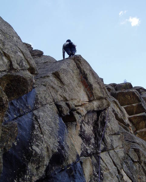 Chuck has just finished the thin traverse moves to the arete. It's still mid 10 above this, but at least now there are some real holds.