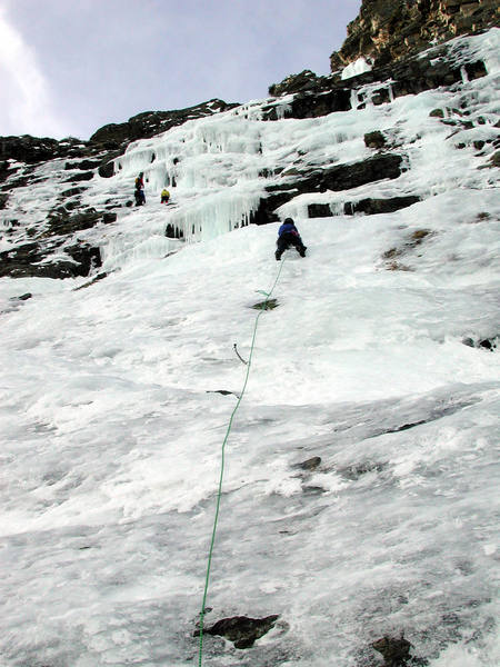 Christa leads up the first pitch avoiding ice fall from climbers above. Our line climbed straight up the steep ice to the right of the other party.