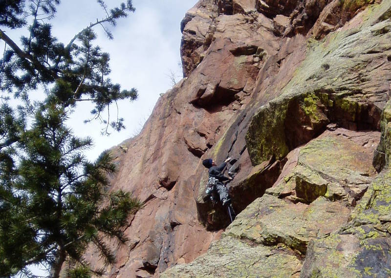 Pulling the roof on P2. Same picture as previous one, but cropped for a close up. This climber climbed the crack directly, but both times I've done it I've stepped right of the crack for a stem rest above the lip of the roof.<br>
<br>
This pitch has become the standard way to do Psychosis, although the original second pitch of Psychosis 9+, the red right facing dihedral left of the climber, is also good.