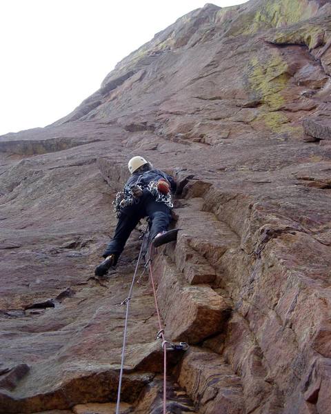 A bunch of small gear adequately protects the first half of the approach. The route steps right just above me and up the easy face to the left facing flakes up and right fom me. The crus is above the leftward slanting celing at the top left of the photo.<br>
<br>
Photo by Luke Clarke.