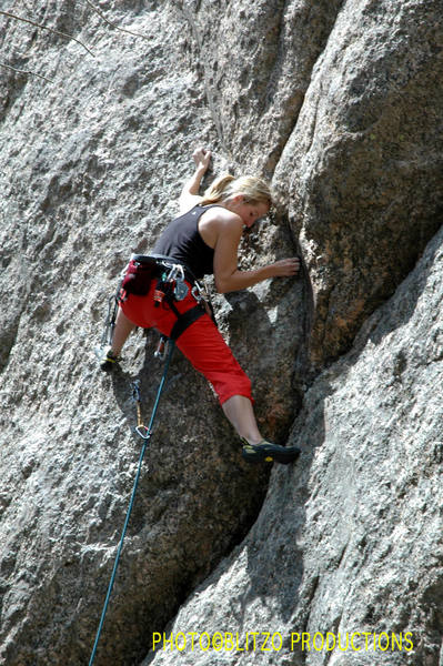 Erin grappling with the crux at the second bolt.