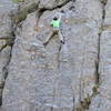 Climber clipping the anchor on Greenback.<br>
<br>
Sustained face climbing on a steep slab makes this a fun route.