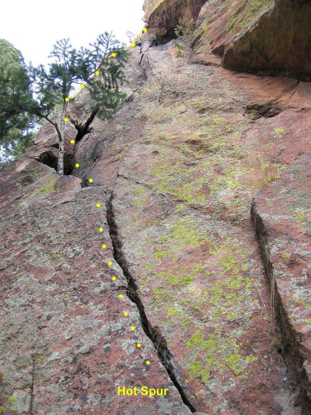 The start of Hot Spur. Climb a left-angling crack to a little pine tree. Continue up another short crack, then angle back right to a chimney/slot with a hand crack in the back.