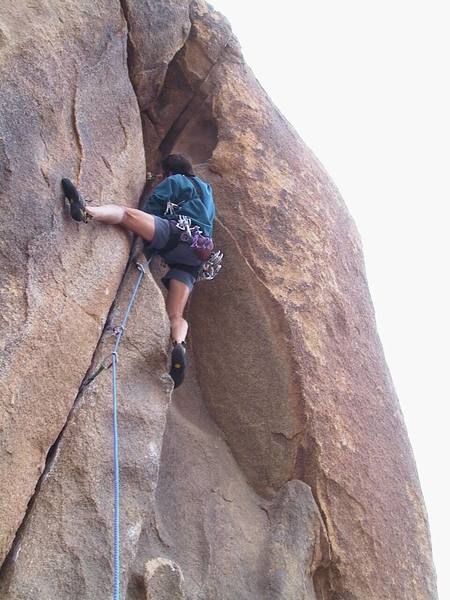 Placing a #2 Camalot at the top of the initial crack. The left-slanting fist crack and thin seam going over the roof are visible