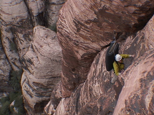 It was a cold day in the fall of 2003 when two intrepid explorers (Sue not pictured) were coerced to climb Olive Oil burdened with crash pads. The destination being a boulder problem in the descent gully which Hans bravely ascended.