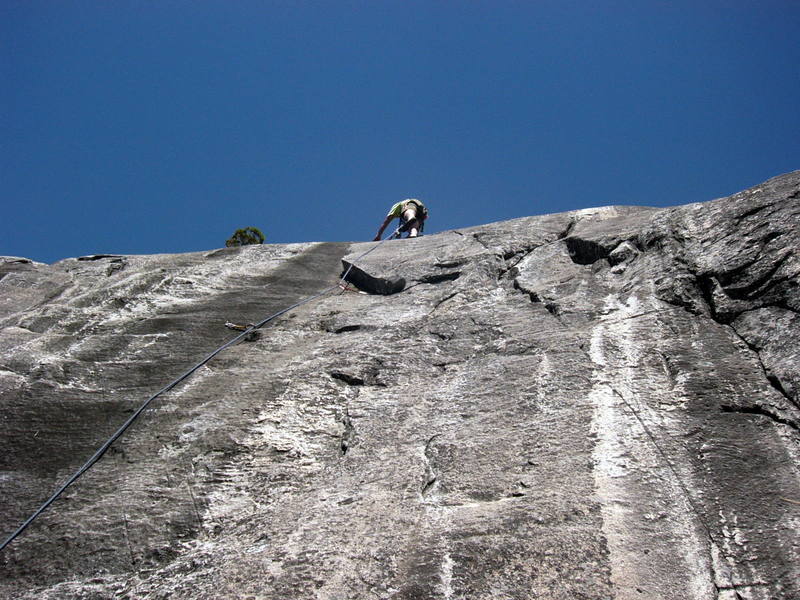 Paul standing on top of flake getting ready to make the thin step out onto the face.