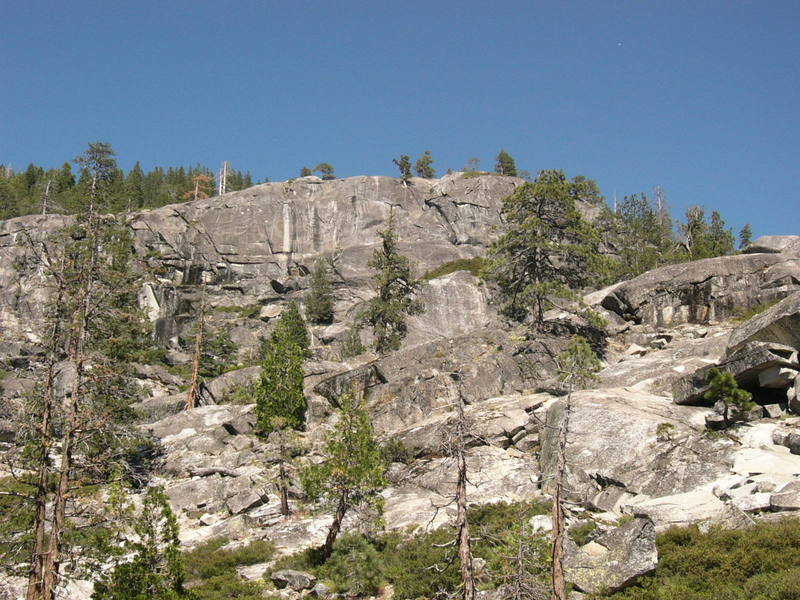 Shot of Indian Springs shown from the parking lot. The Upper Tier is quite obvious with climbs right and left of the large white streak. The Middle Tier is the slightly darker gray section under the right side of the Upper Tier behind pine tree. The Lower Tier partial view is the roundish whiter rock below the right side of the Middle Tier. The Upper Tier has 3 good routes further to the left outside of this photo.