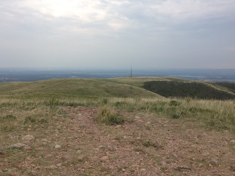 The view from the top of the mountain, a long way traveled with the radio tower and service road visible.