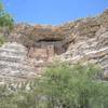Montezuma's Castle can be seen high above the lush green valley below Montezuma's Well.