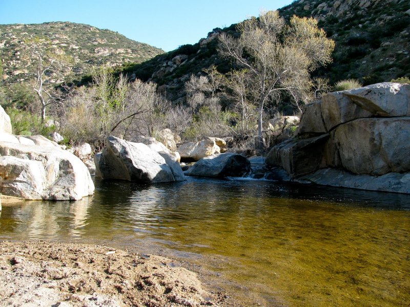 Seasonal swimming hole and waterfall at the south end.