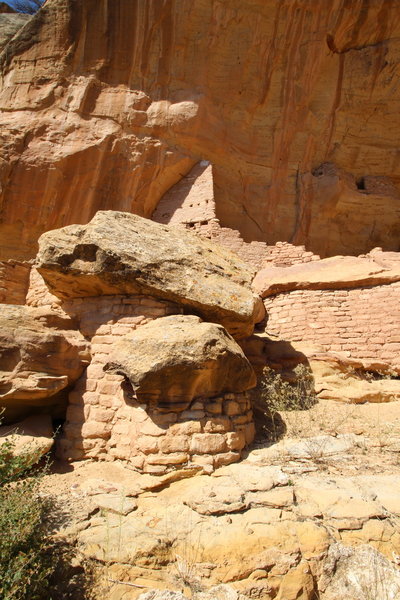 Masonry built around fallen boulders (front), and a multi-story room built to perfectly match the curve of the natural alcove (back). Part of the upper alcove can also be seen in the upper right.