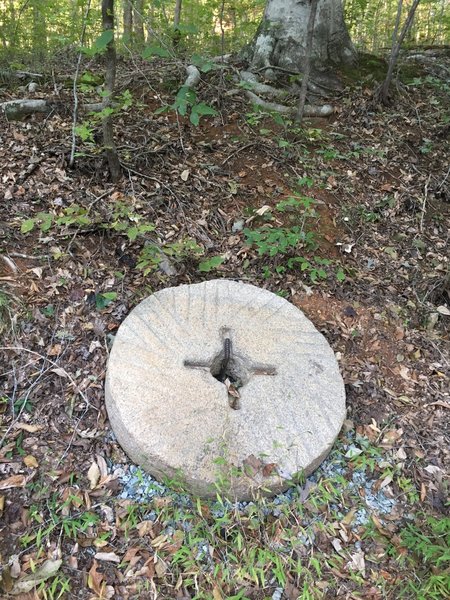 Old millstone on trail.