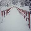 Wooden bridge crossing covered in fresh snow.