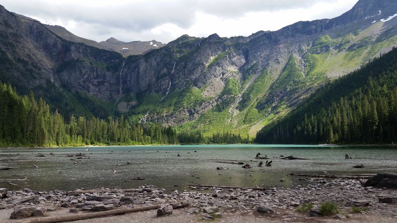 Avalanche Lake rests in the shadow of sheer, towering cliffs.