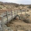 The Bajada Nature Trail begins with a sturdy footbridge over a sandy wash.