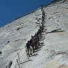 The infamous cable climb on Yosemite's Half Dome rewards visitors with stunning views from the top.