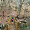 Runners navigate a bridge crossing at the intersection of Lick Creek Trail and the Sheltowee Trace.