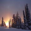 The sun sets over a grove of frosted evergreens on the road to the summit of Pilot Peak.