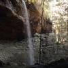 Yahoo Falls cascades over the trail tucked into the shelter of the cave.