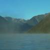 Early morning mist floats atop Lake Rotoiti with the northernmost Southern Alps in the distance.