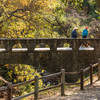 A couple crosses the stone bridge to reach the Penitencia Creek Trail.