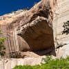 An impressive hole in the canyon wall with a massive overhanging ledge along the Lower Calf Creek Falls Trail.