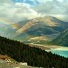 Rainbow over the valley of Berg Lake Trail. Berg Lake (front left), shoulder of Rearguard Mountain (left), and Tatei Ridge in the distance (center). Looking east from the Hargreaves Lake and Glacier Viewpoint.