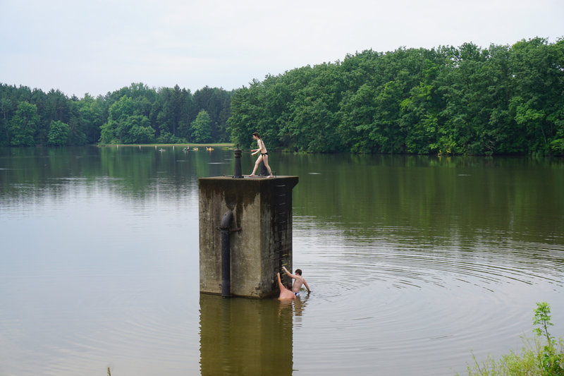Adventurous kids jumping into the lake