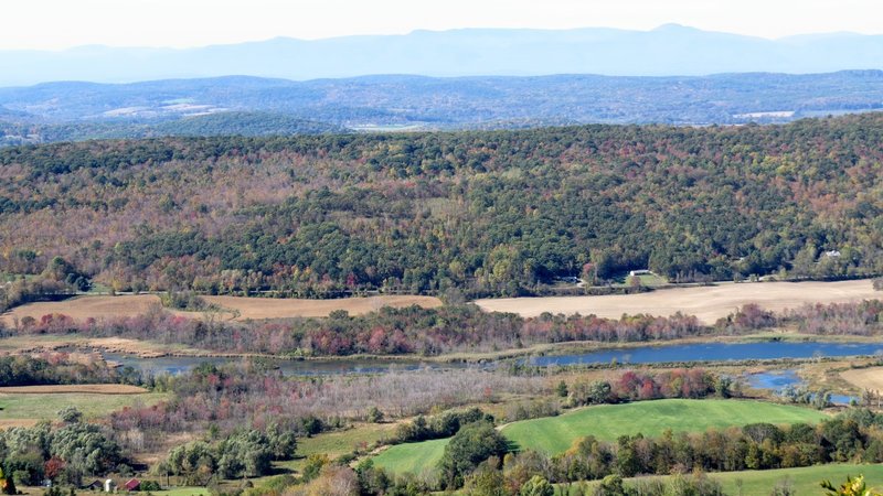 The summit of Brace Mountain offers a colorful view of the Hudson Valley with the Catskill Mountains far in the background