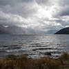 The sun breaking through the clouds on the rainy day looking across Lake Wakatipu