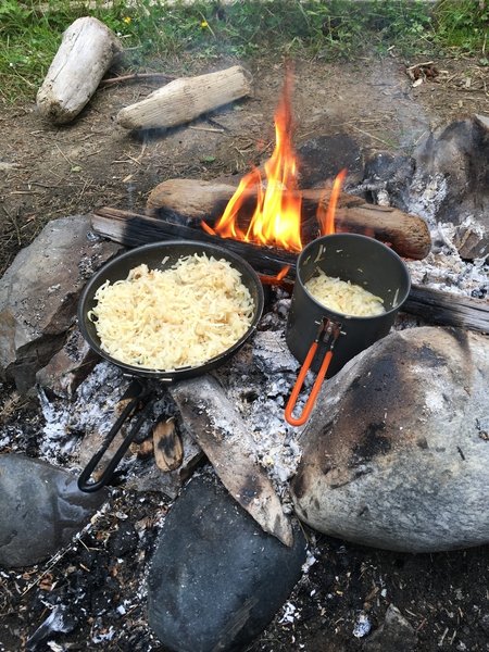 Cooking up dinner over the campfire.