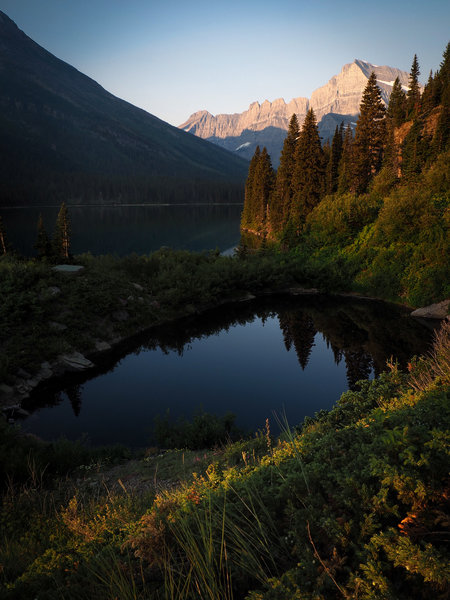 Early morning by Lake Josephine on the Upper Grinnell Lake Trail. Mount Gould illuminated in the distant background.