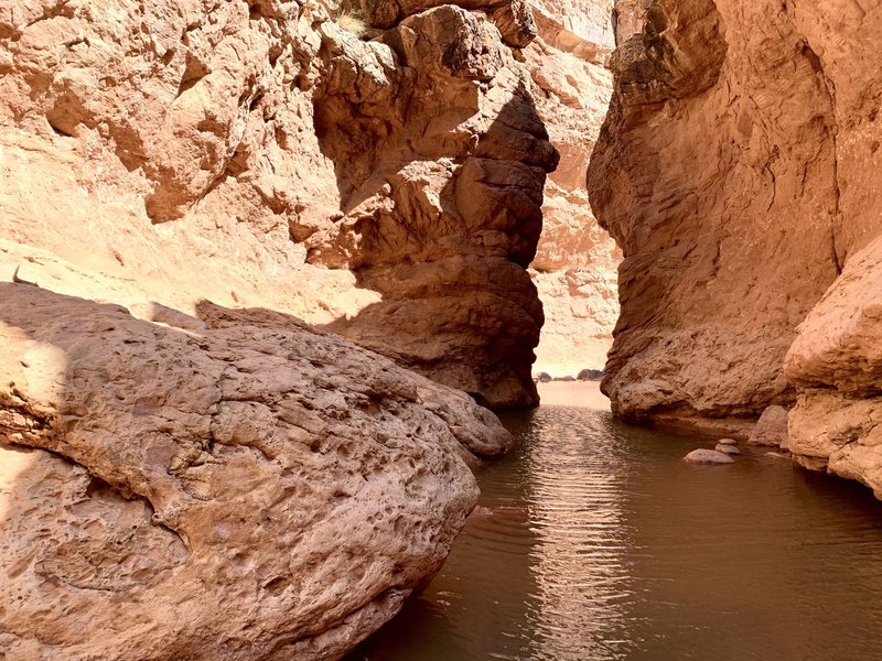 This narrow section is located between the first and second falls. Unless the water levels are unusually low, you'll have to swim for about 100 ft to get through. We went through in mid March and the water was about 5.5 feet deep.