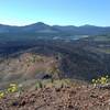 From the rim of Cinder Cone looking south-southeast: Snag Lake in the distance, Mt. Harkness behind right/south end of Snag Lake, Mt. Hoffman (upper center left), Red Cinder and Red Cinder Cone (upper left), Painted Dunes and Fantastic Lava Beds below.